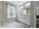 The bright bathroom includes a double vanity, tile floors, and a window for natural light at 15546 Senita Ln, Fishers, IN 46037