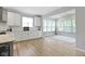 Bright, open kitchen featuring white cabinetry, stainless steel appliances, and hardwood floors at 15546 Senita Ln, Fishers, IN 46037