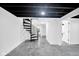 Finished basement with spiral staircase and entryways to other rooms at 1555 N Dearborn St, Indianapolis, IN 46201
