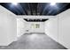 Open basement with an unfinished ceiling, finished floor, and walkout door at 1555 N Dearborn St, Indianapolis, IN 46201