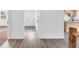 Bright hallway with wood-look flooring and white walls leading to a front door and the kitchen at 1555 N Dearborn St, Indianapolis, IN 46201