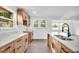 Modern kitchen featuring wood cabinets, quartz countertops, stainless steel sink, and hardwood floors at 1555 N Dearborn St, Indianapolis, IN 46201