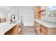 Bright kitchen featuring wooden cabinets, quartz countertop and gooseneck faucet, with a pantry in the background at 1555 N Dearborn St, Indianapolis, IN 46201