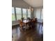 Elegant dining room with a large wooden table, seating for six, and ample natural light from the surrounding windows at 15961 Foothill Dr, Noblesville, IN 46060