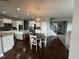 A bright and airy kitchen with a dining area, featuring white cabinetry, stainless steel appliances, and hardwood floors at 15961 Foothill Dr, Noblesville, IN 46060