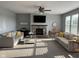 Spacious living room featuring a stone fireplace, large windows, and comfortable neutral-toned furniture at 15961 Foothill Dr, Noblesville, IN 46060