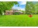 Large backyard showing lush lawn, shade trees, landscaping and back exterior of home at 1660 Obara Ct, Carmel, IN 46033