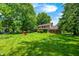 Expansive backyard featuring mature trees, lush lawn, and red seating area at 1660 Obara Ct, Carmel, IN 46033