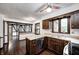 Classic kitchen featuring wood cabinets, stainless steel appliances, and an open layout with dark hardwood floors at 1660 Obara Ct, Carmel, IN 46033