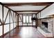 Open living room with hardwood floors, wood beams, a fireplace, and natural light at 1660 Obara Ct, Carmel, IN 46033