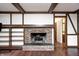 Living room showcasing a cozy brick fireplace, wooden beams, and a built-in bookshelf at 1660 Obara Ct, Carmel, IN 46033