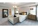 The primary bedroom suite features a king bed, ensuite bath and a cozy seating area at 17050 Daly Dr, Noblesville, IN 46062