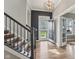 Grand foyer with hardwood floors, an elegant chandelier, stairs with metal railings, and an open doorway at 2105 Granville Dr, Westfield, IN 46074
