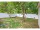 A fenced backyard features green grass, trees, and a white vinyl privacy fence providing a secure and secluded outdoor space at 2289 Salem Park Dr, Indianapolis, IN 46239