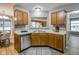 Bright kitchen featuring stainless steel dishwasher, wood cabinets, and an opening looking into the living room at 2289 Salem Park Dr, Indianapolis, IN 46239