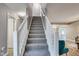 Carpeted staircase with white banister, leading to the upper level, adds charm and functionality to the home's interior at 2289 Salem Park Dr, Indianapolis, IN 46239