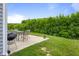 Backyard patio with seating and barbecue area, overlooking a yard with trees and open sky at 2421 Creek Bank Dr, Columbus, IN 47201