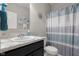 Bathroom with a single sink, granite countertop, and white and blue striped shower curtain at 2421 Creek Bank Dr, Columbus, IN 47201