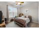 Bedroom with a ceiling fan, large window with blinds, and plush carpet at 2421 Creek Bank Dr, Columbus, IN 47201