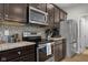 Well-equipped kitchen with dark wood cabinets, granite counters, and stainless steel appliances at 2421 Creek Bank Dr, Columbus, IN 47201