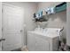 Clean and functional laundry room with modern washer and dryer and overhead shelving at 2421 Creek Bank Dr, Columbus, IN 47201