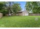 Fenced backyard features green lawn and a garage, with mature trees at 2610 Caroline Ave, Indianapolis, IN 46218