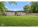 A fenced-in backyard with a well-maintained lawn, and gray sided home at 2610 Caroline Ave, Indianapolis, IN 46218