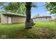 A backyard with a garage, house, green lawn, and mature trees at 2610 Caroline Ave, Indianapolis, IN 46218