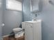 A tidy, blue-walled bathroom offers a toilet and sink with a mirror at 2610 Caroline Ave, Indianapolis, IN 46218