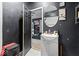 Bathroom with a dark painted door, light vanity and round mirror at 2610 Caroline Ave, Indianapolis, IN 46218