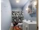 A blue bathroom with a black and white shower curtain and a white sink at 2610 Caroline Ave, Indianapolis, IN 46218