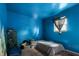 A bright blue bedroom with a single bed, window, and carpeted floor at 2610 Caroline Ave, Indianapolis, IN 46218