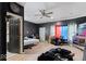 A bedroom featuring colorful curtains, fan, wood floors, and dark painted walls at 2610 Caroline Ave, Indianapolis, IN 46218