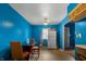 View of the bright blue kitchen with linoleum floors, white refrigerator, and small dinette at 2610 Caroline Ave, Indianapolis, IN 46218