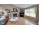 Living room with vaulted ceiling, fireplace, wood-look flooring, and a large window at 3025 Sable Ridge Ln, Greenwood, IN 46142