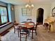 Sunlit dining room featuring a classic chandelier, archway, and adjacent piano at 313 S Brittain Ave, Muncie, IN 47303