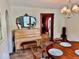 Elegant dining room with vintage mirror, piano, and view to the adjacent kitchen at 313 S Brittain Ave, Muncie, IN 47303