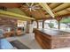 Enclosed patio featuring vaulted wood ceilings, brick accent wall, and hot tub at 3707 E Wilson Dr, Mooresville, IN 46158