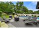 Backyard pool with chairs, slide, and mature trees, ideal for outdoor enjoyment at 3707 E Wilson Dr, Mooresville, IN 46158