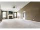 Spacious living room featuring neutral carpet, a ceiling fan, and a cozy fireplace with mantle at 3872 Dusty Sands Rd, Whitestown, IN 46075