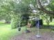 Backyard featuring mature trees, a bench, and playground equipment including a rope swing at 403 N College Ave, Greencastle, IN 46135