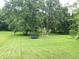 Large backyard with mature trees, a trampoline, and a swing set for outdoor recreation at 403 N College Ave, Greencastle, IN 46135