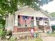 Charming porch decorated with flags and flowers, offering a welcoming curb appeal to the home at 403 N College Ave, Greencastle, IN 46135