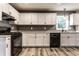 Updated kitchen featuring white cabinets, wood-look flooring, contrasting grey walls, and stainless steel appliances at 4191 N Graham Rd, Whiteland, IN 46184