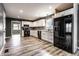 Modern kitchen with white cabinets, wood-look flooring, stainless steel appliances, and contrasting black accents at 4191 N Graham Rd, Whiteland, IN 46184