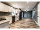 Bright kitchen featuring white cabinetry, wood-look floors, stainless steel appliances, and easy access to the living area at 4191 N Graham Rd, Whiteland, IN 46184