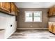 Utility room with wood cabinets, a large window and light wood-look flooring at 4191 N Graham Rd, Whiteland, IN 46184
