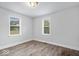 Light-filled bedroom with two windows and wood-look laminate flooring at 4310 Crittenden Ave, Indianapolis, IN 46205