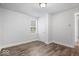 Light and airy bedroom showing neutral walls, window, and wood-look laminate flooring at 4310 Crittenden Ave, Indianapolis, IN 46205