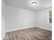 Well-lit bedroom showcasing neutral walls, wood-look laminate flooring, and a window at 4310 Crittenden Ave, Indianapolis, IN 46205